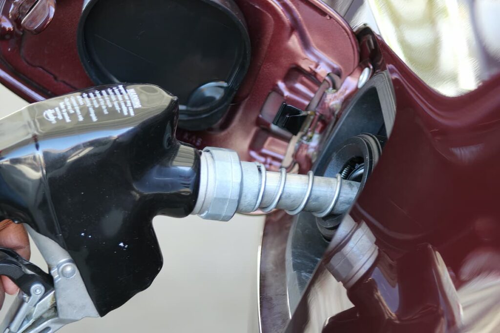 Close up de uma mangueira de combustível a atestar um carro