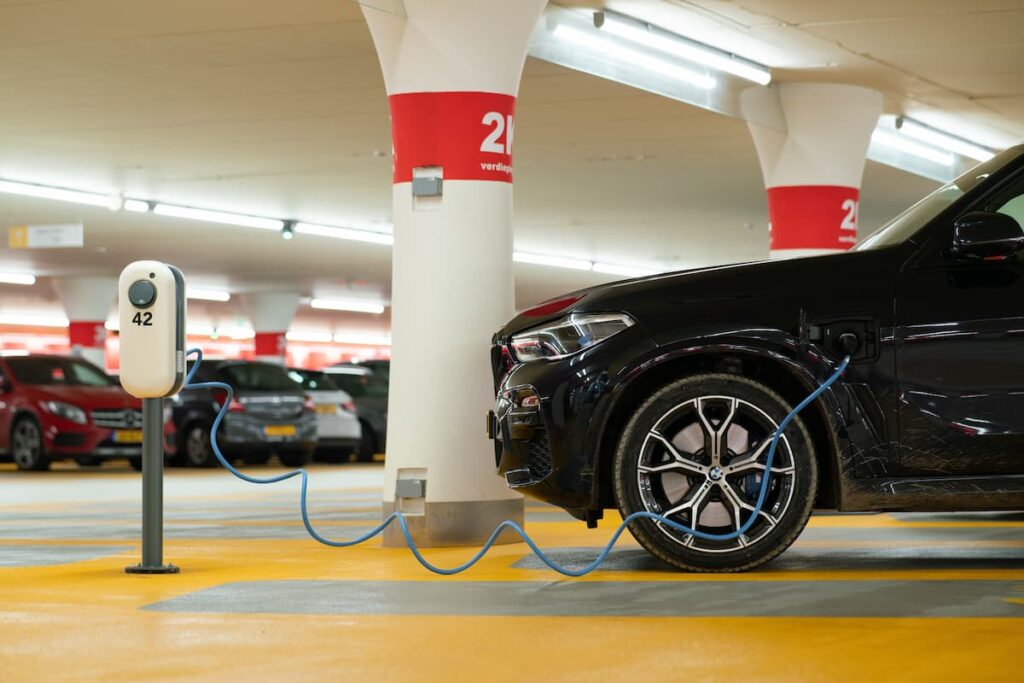 Black electric car charging at a station in a shopping center