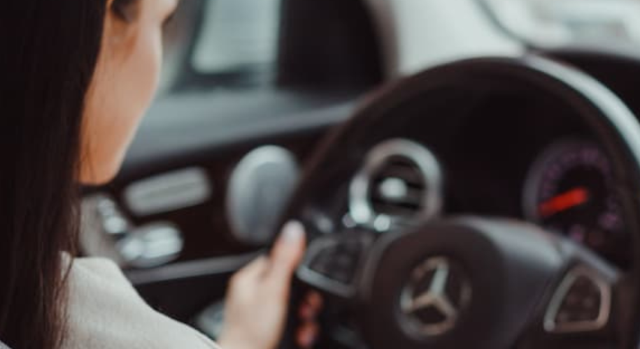 Woman driving a Mercedes with assisted steering