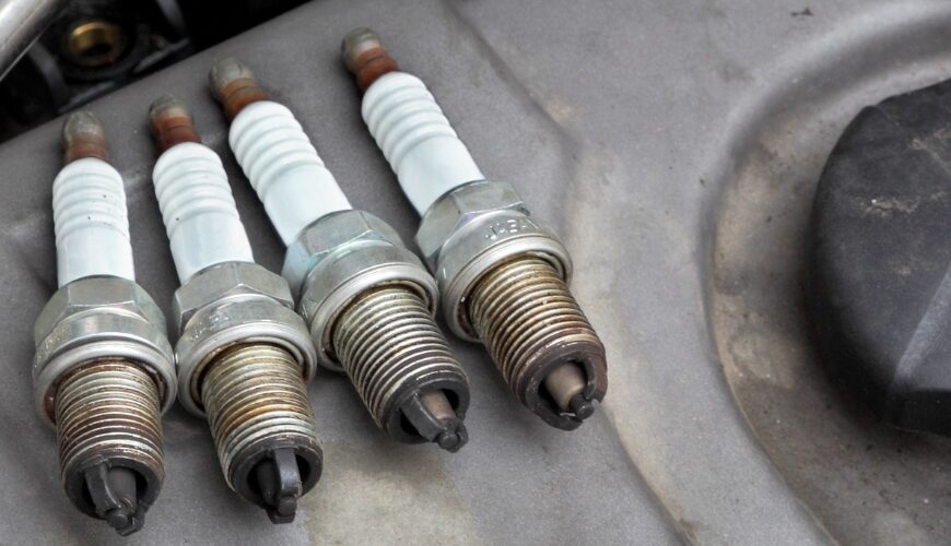 Three spark plugs next to the water deposit of a car