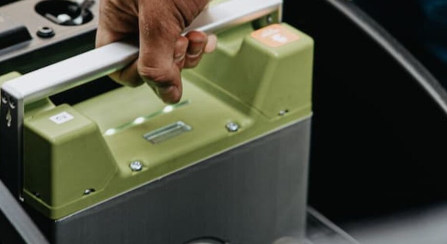 Mann greift nach einer Autobatterie