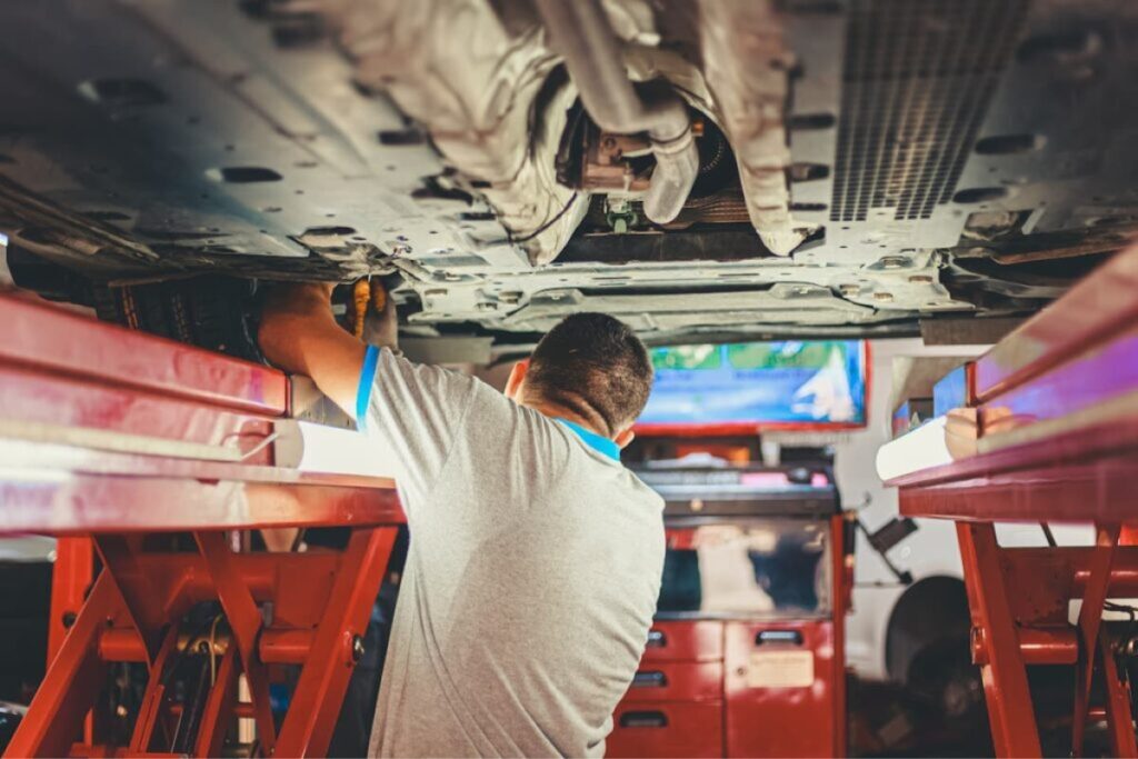 Mechaniker bei der Reparatur der Unterseite eines Autos