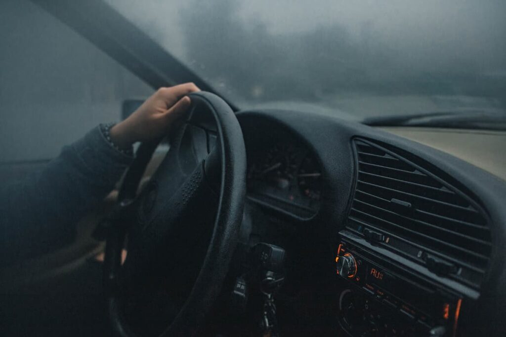 Homme conduisant une voiture dans le brouillard