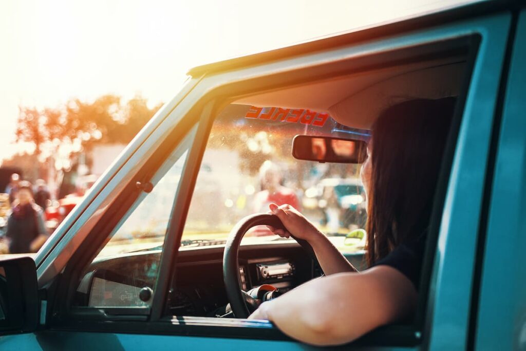 Woman drives a blue car and uses eco-driving.