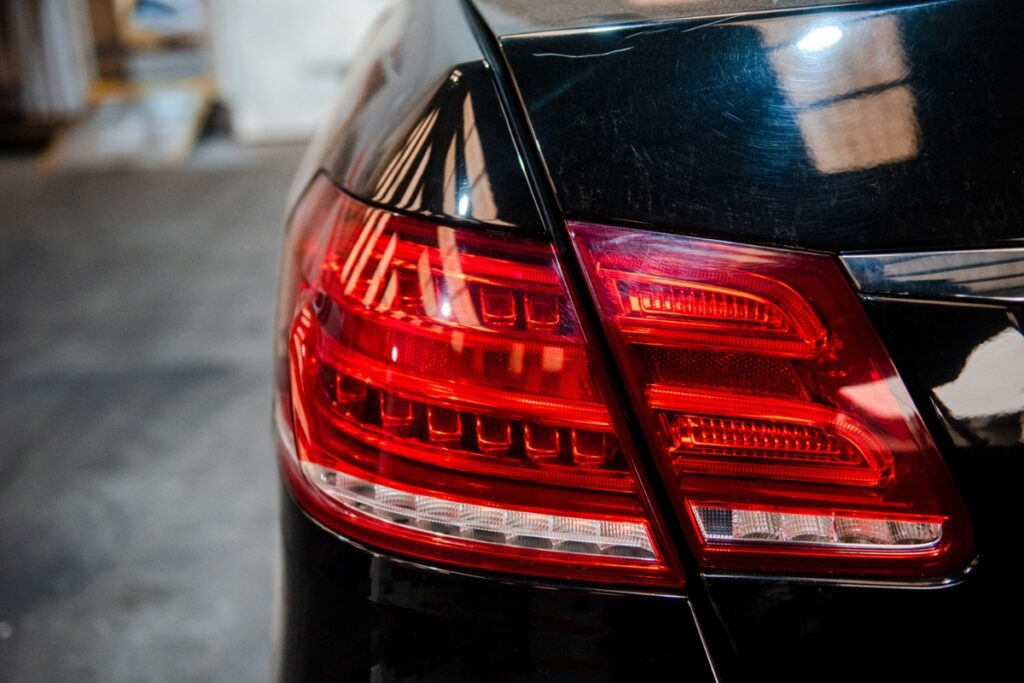 Rear of a black car with the headlight highlighted