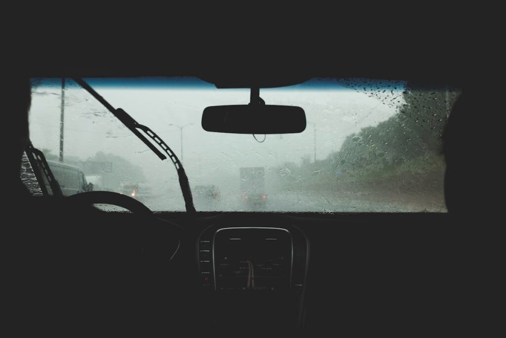 Pessoa a conduzir na chuva, com o limpa-para-brisas ligado