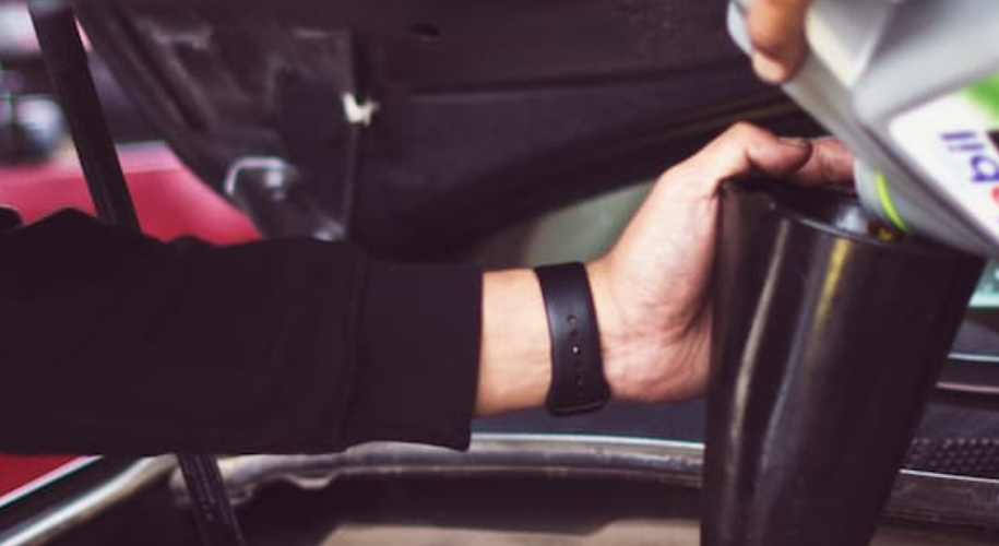 Mechanic changes the car oil in a customer's car
