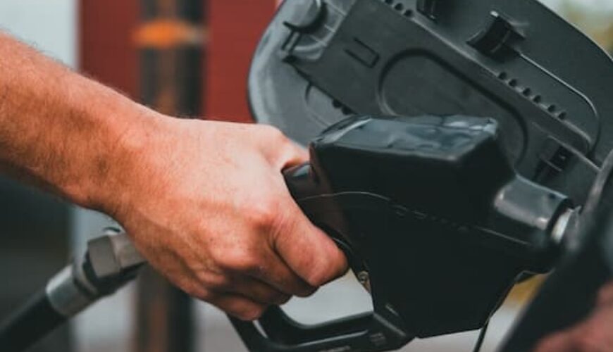Close-up van een hand met een benzineslang die een auto vult